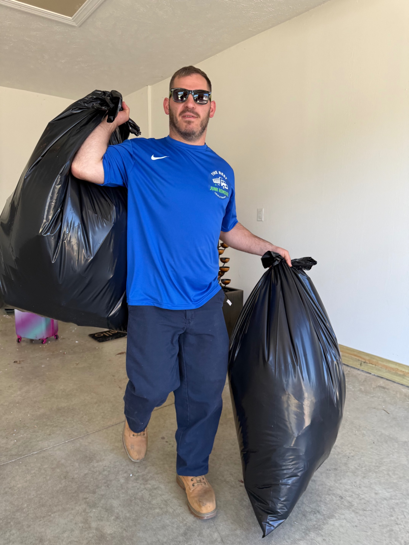 Andy, owner of TheBestJunk, hauling out heavy-duty contractor bags during a same-day garage cleanout in Northeast Ohio