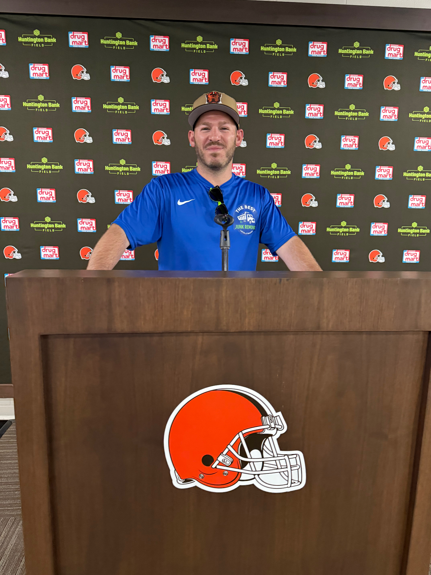 Andy, owner of The Best Junk Removal Cleveland, at the Cleveland Browns Huntington Bank Field press podium wearing a branded TheBestJunk shirt