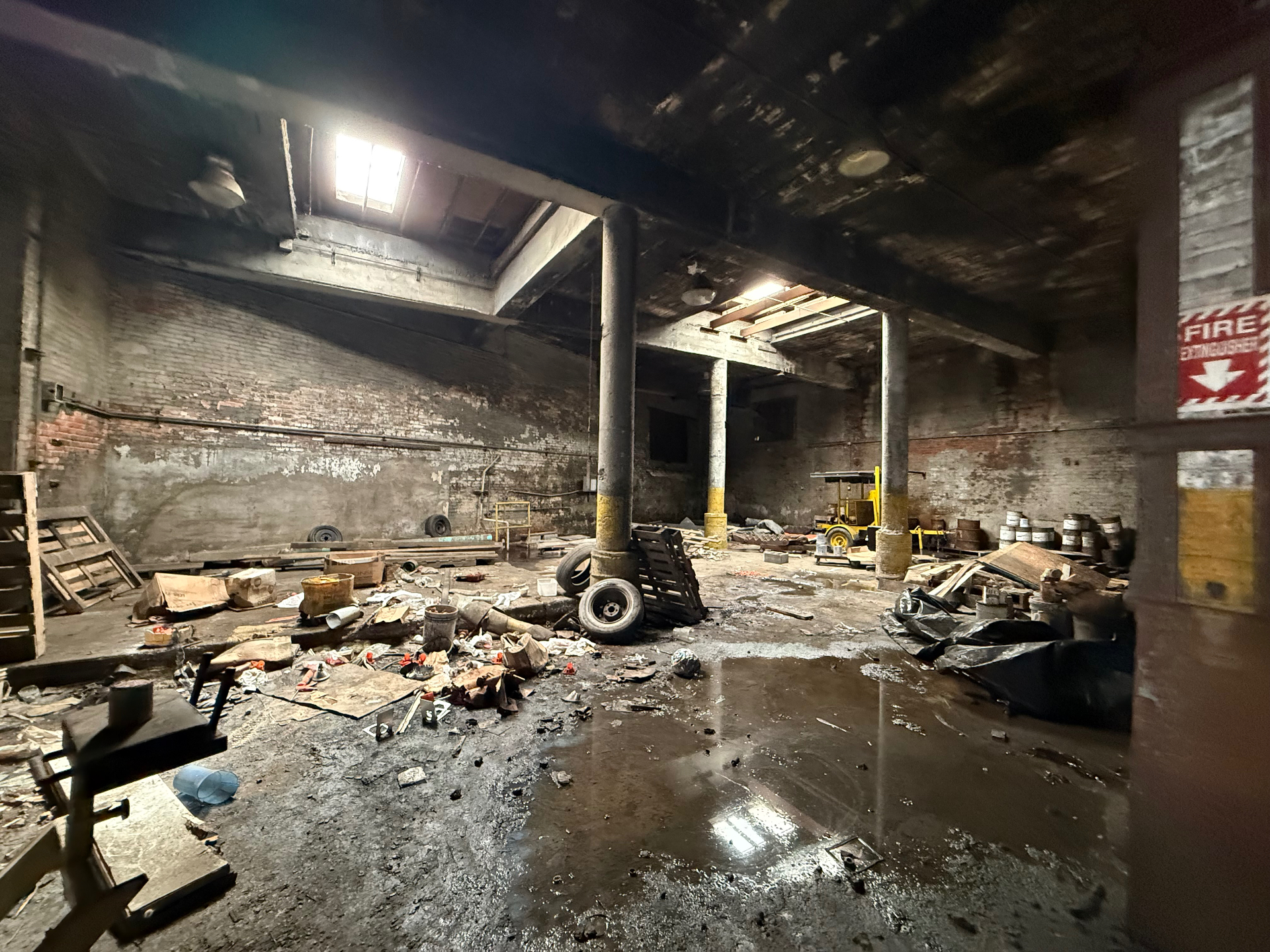 Large industrial warehouse interior with debris and equipment ready for a full warehouse cleanout
